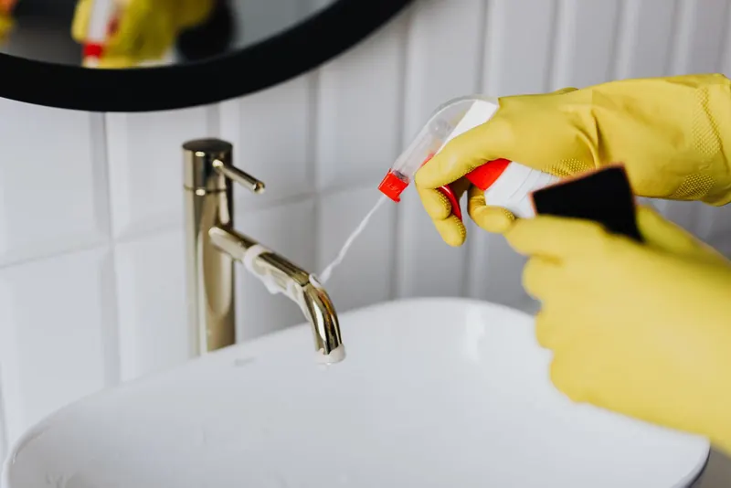 Sink and faucet being sprayed and polished