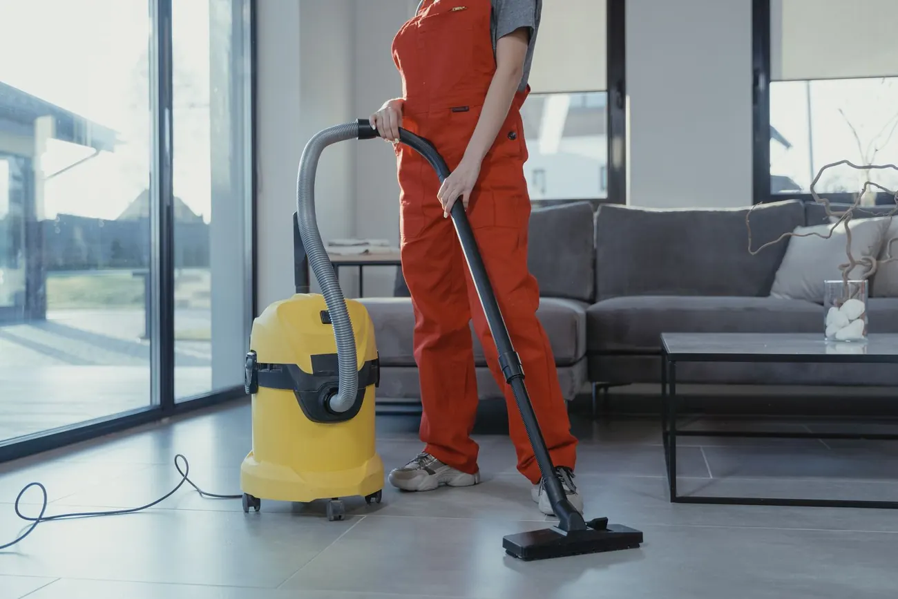 Cleaner vacuuming a modern living room