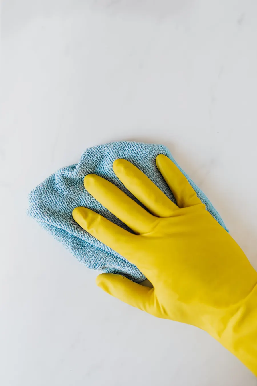 Gloved hand wiping a surface to a spotless finish