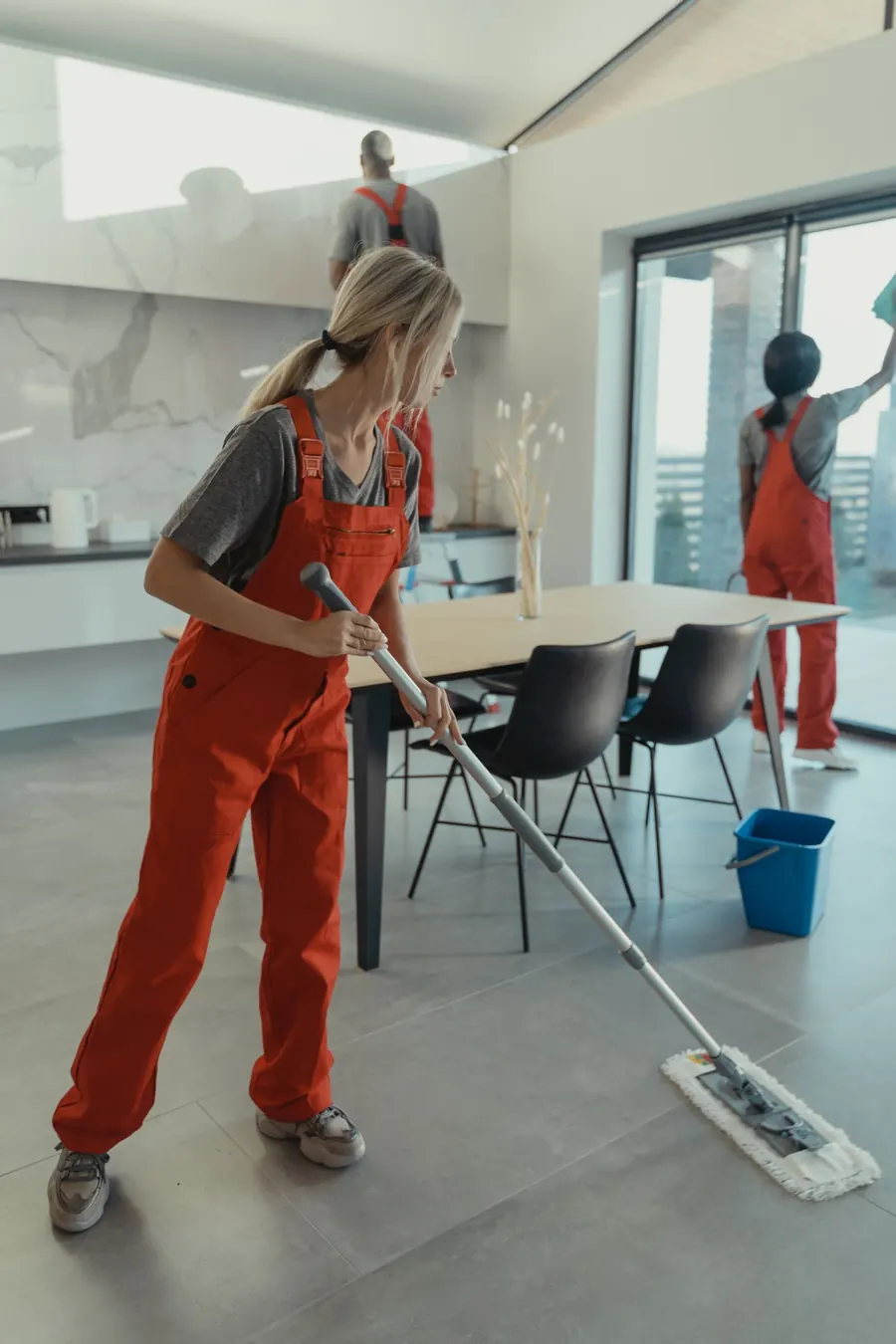 Cleaner mopping a bright, modern living space